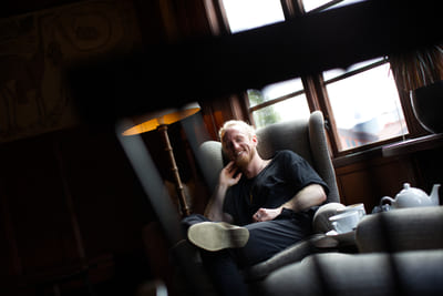 Fredrik Brännlund, founder of Noa The Game Fredrik Brännlund leaning back in an armchair with his legs drawn up, a teapot in the foreground