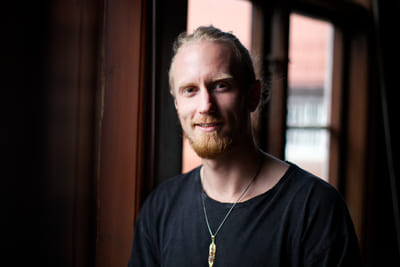 Fredrik Brännlund, founder of Noa The Game Fredrik Brännlund in a black t-shirt by a window in backlight